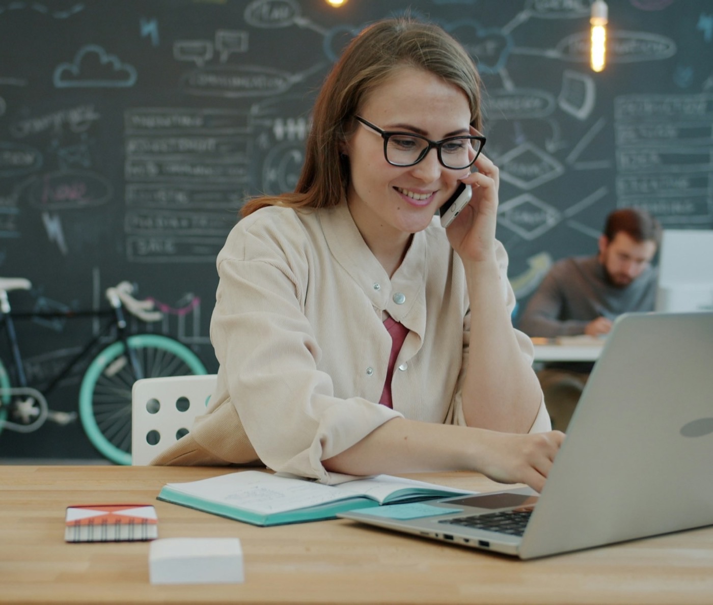 A smiling PA on the phone while working at her laptop